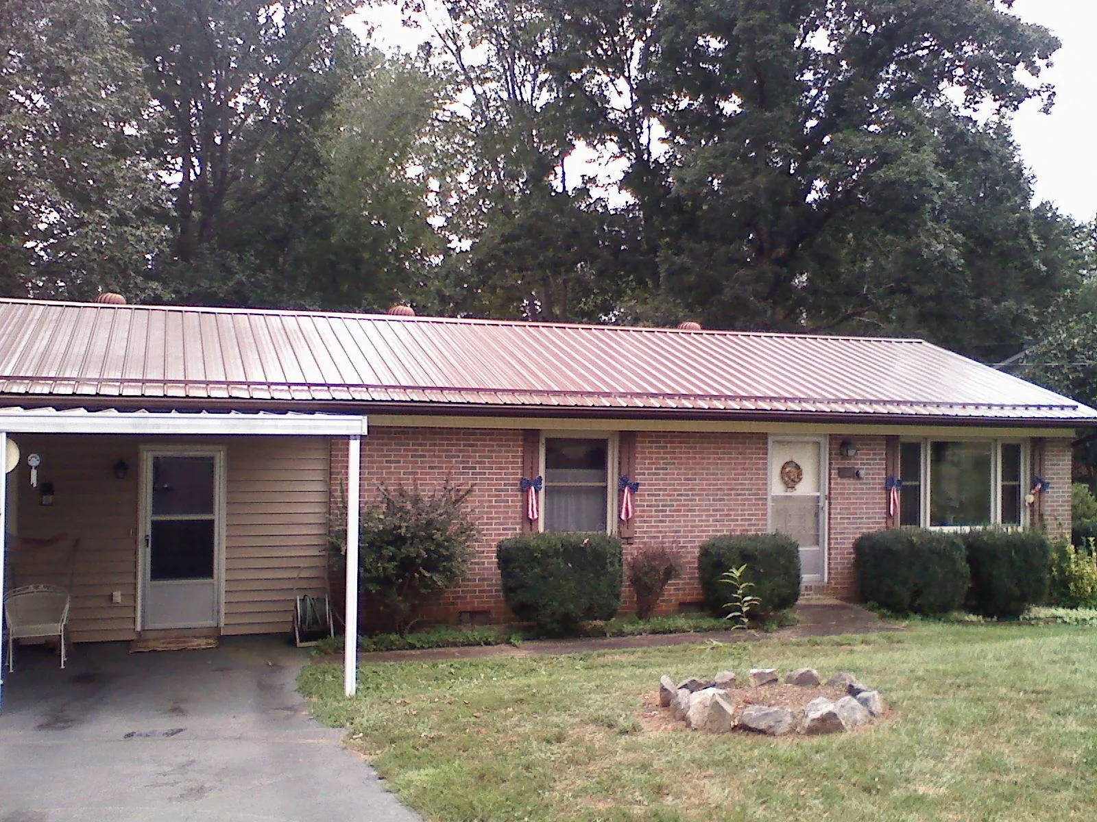 Bronze metal roof and carport on a brick ranch home — Roof Repair work by our crew in Augusta